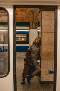 a woman with her face painted like a cat is standing in the doorway of a subway train