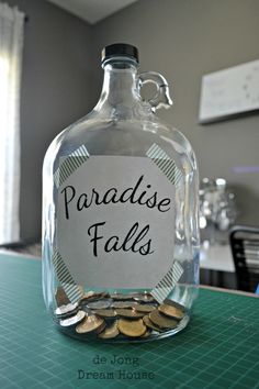 a glass bottle filled with coins sitting on top of a table