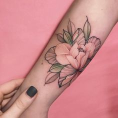 a woman's arm with a flower tattoo on it