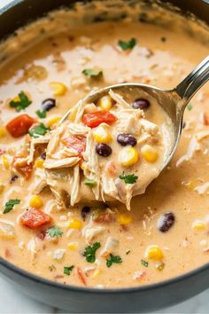 a spoonful of chicken tortilla soup with corn and tomatoes