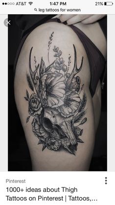 a woman's thigh with flowers on it and a cow skull in the middle