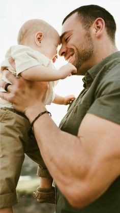 a man holding a baby up to his face