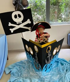 a child in a pirate ship made out of cardboard