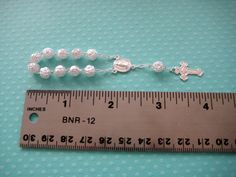 These beautiful pearl mini-rosary with attention to details, they made out of acrylic beads and metal link chain. It includes a silver chain cross. Mini rosaries perfect for baptism favors, first communion favors, Christening Favors, invitation cards, and other religious celebrations. Length: Approx. 4 inches Quantity: 10 rosaries Please note: the mini rosaries can't be used as a bracelet. For more Baptism and Christening Favors: https://www.etsy.com/shop/TinyLittleCharms?section_id=16004987&amp Silver Baptism Jewelry With 8mm Beads, Silver Rosary Bracelet With Round Beads For First Communion, Silver Jewelry With 8mm Beads For Baptism, Silver Rosary Bracelet With Round Beads For Baptism, Mini Rosaries, First Communion Favors, Communion Favors, Christening Favors, Baptism Favors