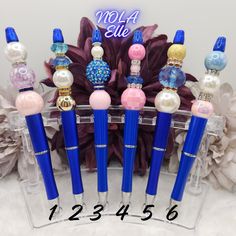 six blue and pink pens with pearls on them