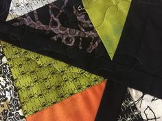 an assortment of different colored and black quilts