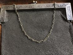 "This is an excellent evening bag - if you don't' wish to conceal anything in it. It is lovely. The bag is comprised of a chain mail mesh in German silver which descends from a stamped frame of German silver with a silvered brass clasp and chain. It is marked on its handle with an eye pictogram and the words German silver. The eye indicates that is was made by JT Inman, a silver company founded in Attleboro MA in 1882. The bag is pretty large for its type. It is 10\" wide X 9\" long. The chain i Formal Silver Bag With Chain, Elegant Silver Bag With Chain, Elegant Silver Bags With Chain Detail, Silver Formal Bag With Chain Strap, Silver Evening Bag With Chain Detail, Silver Evening Bag With Chain For Everyday Use, Silver Evening Bags With Chain, Silver Rectangular Evening Bag With Chain Strap, Silver Evening Bag With Chain For Gift