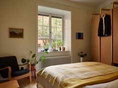 a bed room with a neatly made bed next to a window and a radiator