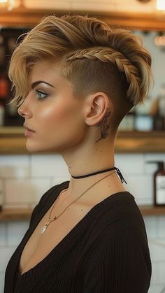 Revamp your short hair with the bold French Braid Mohawk for Undercut Pixies! This edgy hairstyle combines elements of elegance and rebellion, perfect for those who dare to stand out. Explore more quick and cute hairstyles for short hair by clicking now! 💇‍♀️ #ShortHairStyles #FrenchBraidMohawk #UndercutPixie #EdgyHair #HairstyleInspo Viking Braids Female Mohawk, Nordic Braids Short Hair, Mohawk Braid Short Hair, Faux Hawk Updo Short Hair, Under Shaved Hair Undercut For Women, Short Hairstyle With Shaved Sides, Modern Mohawk For Women, Short Hair With Braid, Short Viking Hair