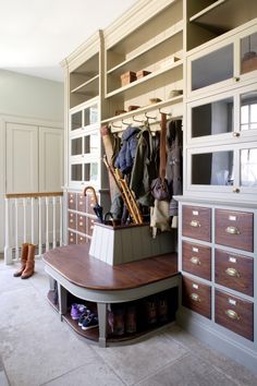 an organized closet with shoes, coats and umbrellas