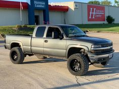 a silver truck parked in front of a building