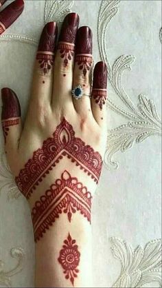 a woman's hand with henna tattoos on it