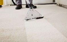 a person is cleaning the carpet with a vacuum