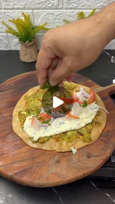 a person is cutting up some food on a wooden board