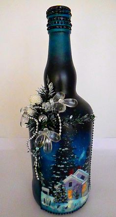 a glass bottle with a christmas scene on the side and snowflakes around it