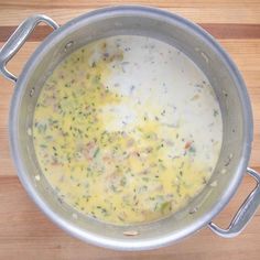 a pot filled with soup sitting on top of a wooden table