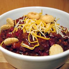 a white bowl filled with chili and crackers