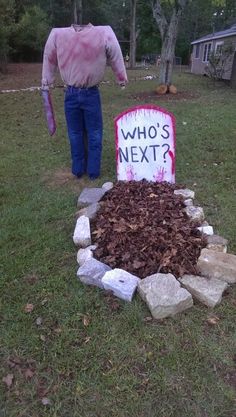 a man standing next to a pile of leaves and a sign that says who's next?