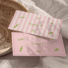 two pink and white cards sitting on top of a bowl