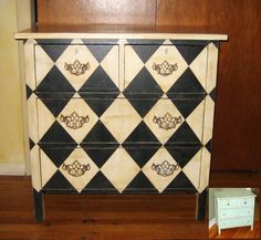 a black and white checkered dresser next to a wooden cabinet with drawers on it