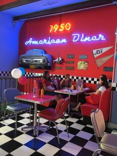 the interior of an american diner with red booths and black and white checkered floor