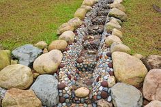 there is a long stream made out of rocks in the middle of some grass and stones