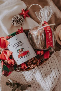 a basket filled with cookies and treats on top of a blanket next to pine cones