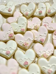 some heart shaped cookies are sitting on a plate with pink and white frosted icing