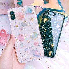 two phone cases with glitter stars and planets on them, one is blue and the other is pink