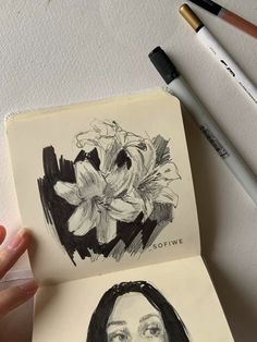 a drawing of a woman's face with flowers in the background and two markers next to it