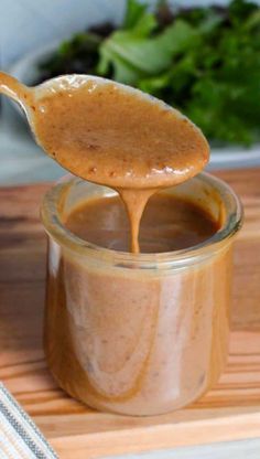 a spoon full of peanut butter on top of a wooden cutting board