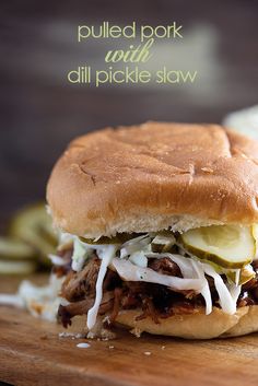 a pulled pork sandwich with pickles and onions