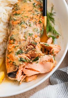 a white plate topped with salmon and rice