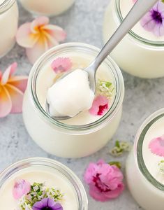 three jars filled with yogurt and flowers