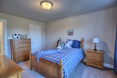 a bed room with a neatly made bed and dresser