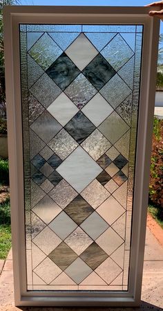 a large stained glass window sitting on the side of a sidewalk in front of a building