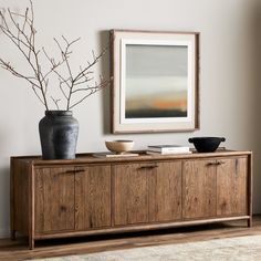 a living room scene with focus on the sideboard and vase in the foreground