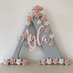 the letters are made out of wood and have flowers on them, with one letter that says