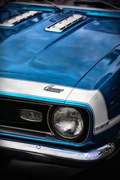 the front end of a blue and white muscle car