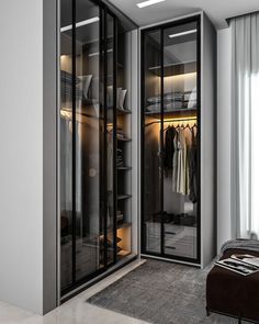 a walk - in closet with glass doors and shelves