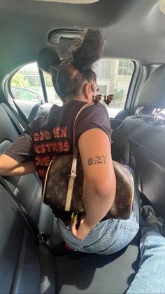 a woman sitting in the back seat of a car with her hand on her hip