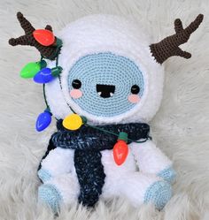 a crocheted stuffed animal with christmas lights on it's head and antlers