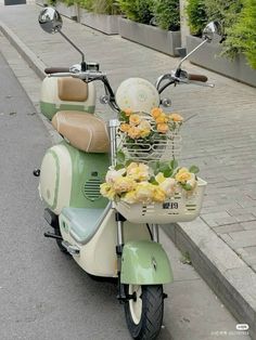 a scooter with flowers in the basket is parked on the street