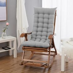 a rocking chair in a living room next to a window