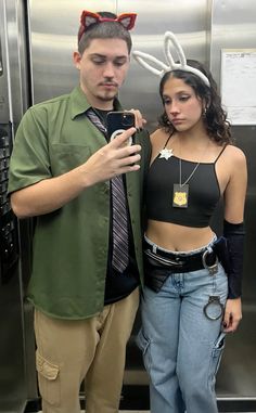 a man and woman standing next to each other in front of a metal refrigerator door