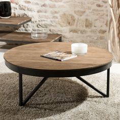 a coffee table sitting on top of a carpeted floor next to a brick wall