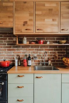 A kitchen featuring a brick backsplash paired with maple cabinets and warm wood countertops. Kitchen With Maple Cabinets, Cabinet Inspiration, Maple Kitchen Cabinets, Maple Cabinets