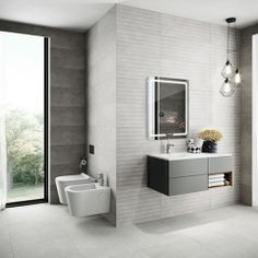 a bathroom with a toilet, sink and mirror in it's center wall next to a large window