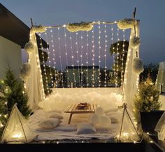 a bed with lights and pillows on it in the middle of a night time scene