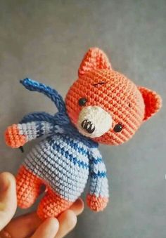 a small crocheted teddy bear is being held by someone's hand,